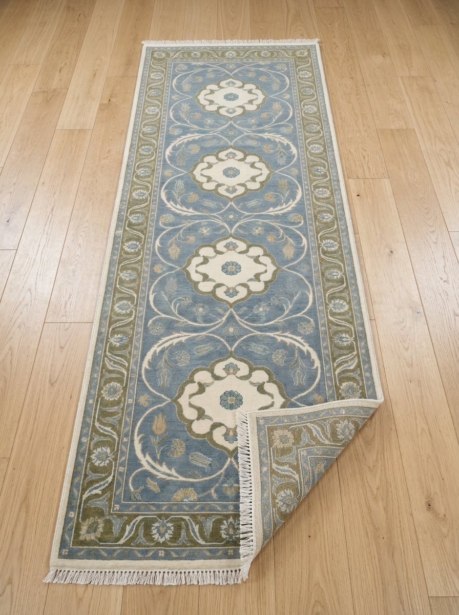 Hand Knotted Oushak Runner Rug in muted blue wool, with ivory floral medallions, olive vine border and fringe.