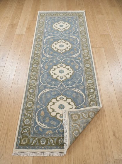 Hand Knotted Oushak Runner Rug in muted blue wool, with ivory floral medallions, olive vine border and fringe.