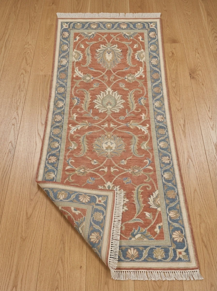 Hand Knotted Oushak Runner Rug in terracotta wool, with ivory floral vines, muted blue border and fringed ends.