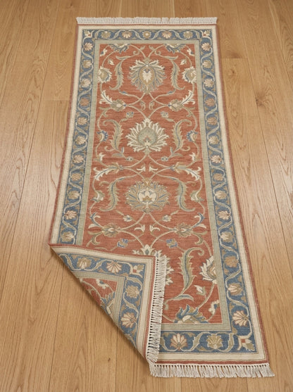 Hand Knotted Oushak Runner Rug in terracotta wool, with ivory floral vines, muted blue border and fringed ends.