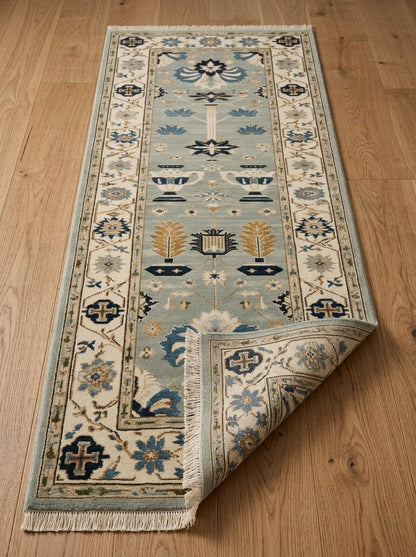 Hand Knotted Oushak Runner Rug in soft blue wool with ivory floral borders, navy and copper motifs, and fringe.