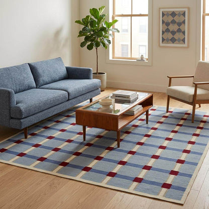 Pale blue flatweave wool rug with red and ivory grid check pattern in modern living room setting