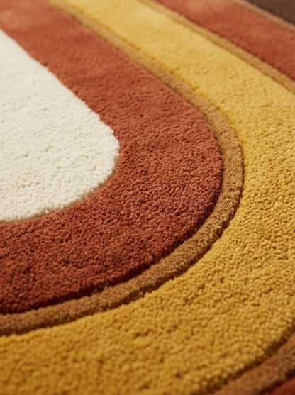 Retro Oval Runner Rug with plush wool pile, showing curved ivory, rust, mustard and caramel bands with carved outlines