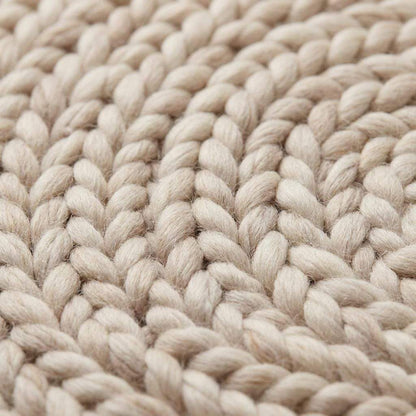 Round chunky knit wool rug in cream, handwoven Merino wool with Scandinavian minimalist design for cozy nursery or living room decor