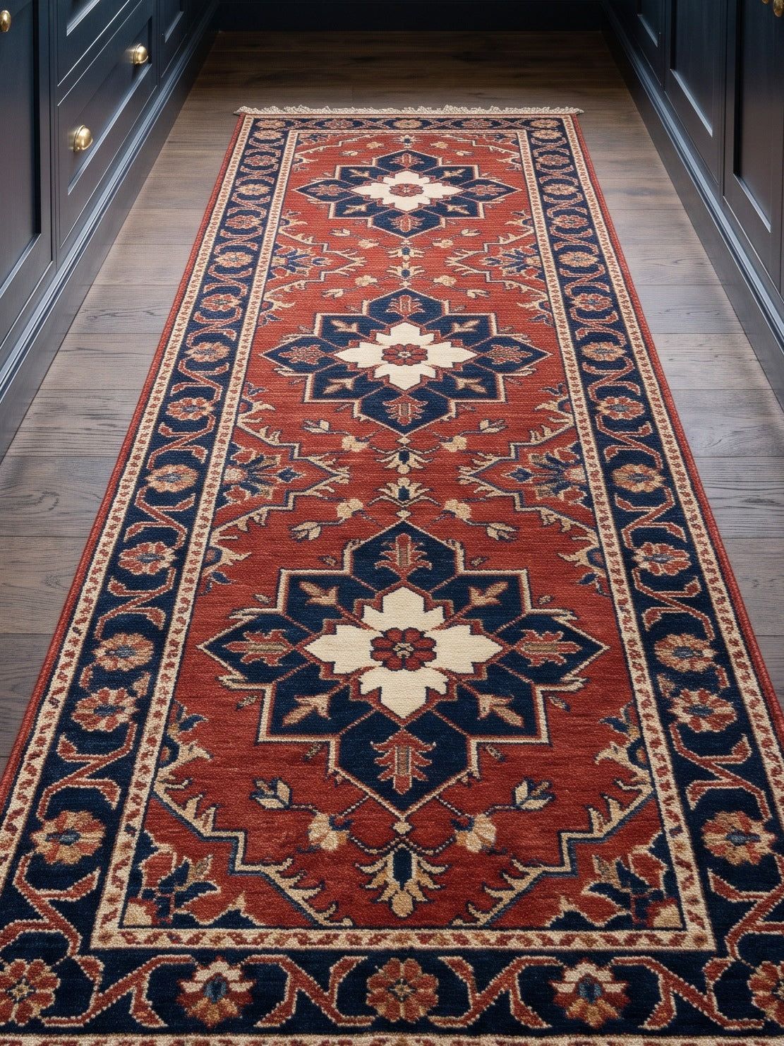 Rust Red Heriz Runner Rug with a rust red wool field, three navy and ivory geometric medallions, floral border and fringe