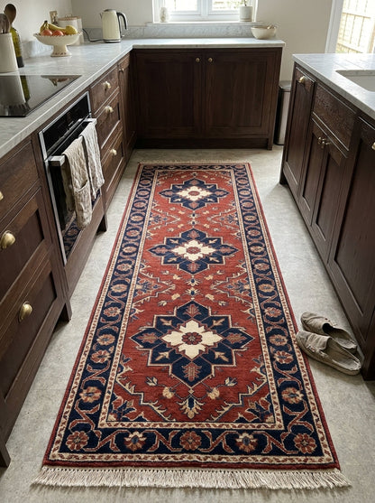 Rust Red Heriz Runner Rug in wool with a rust red field, navy and ivory geometric medallions, floral border and fringe