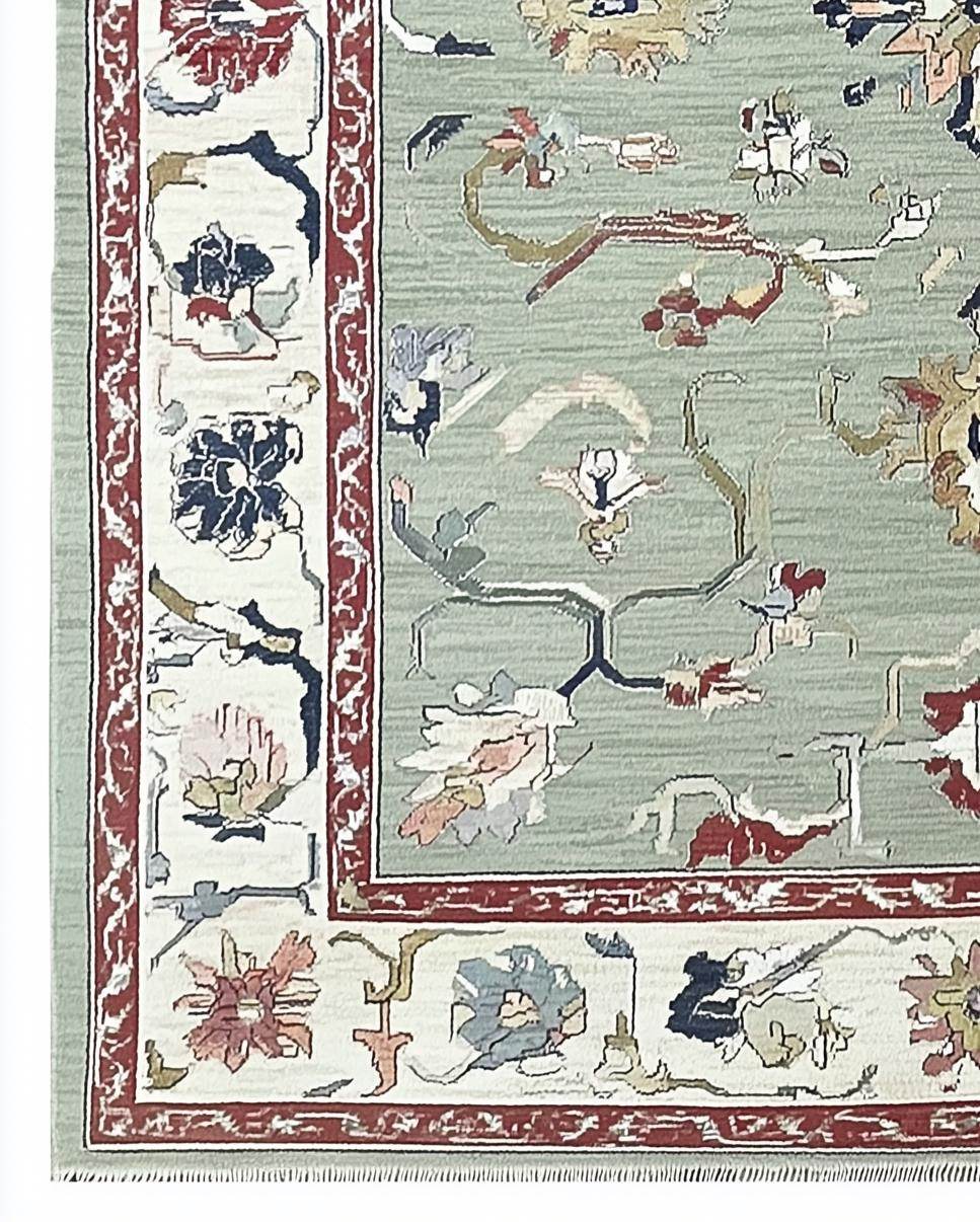 Sage green Oushak rug with floral and vine patterns in hand-tufted wool, featuring muted terracotta, navy, and cream accents.