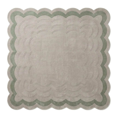 Sage Green Scalloped Echo hand-tufted wool rug in pale greige and sage green, with carved rippling lines and scalloped edges.