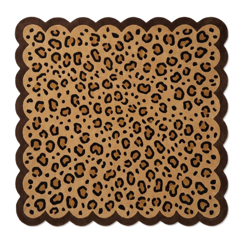 Scalloped Leopard Rug in tan with black animal spots and a thick dark brown border, featuring a wavy edge
