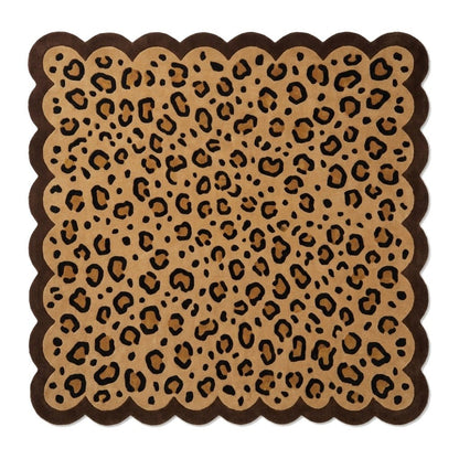 Scalloped Leopard Rug in tan with black animal spots and a thick dark brown border, featuring a wavy edge