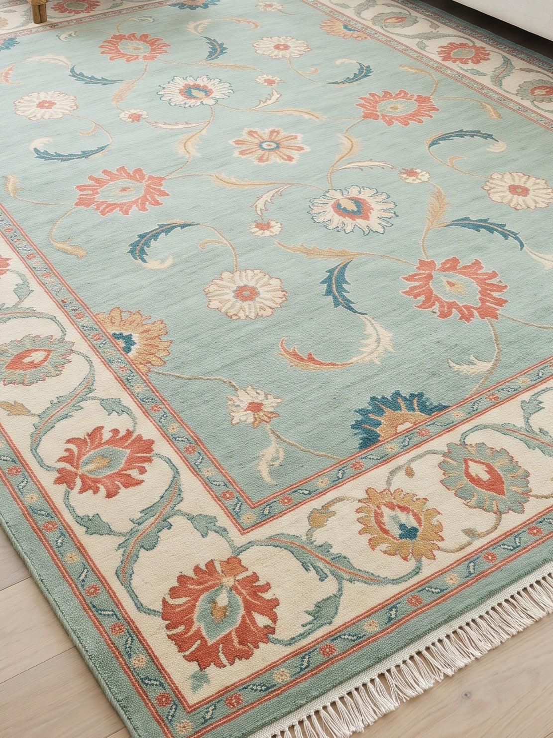 Seafoam Oushak Rug in wool with coral, teal and ivory floral motifs, wide ivory border and fringe