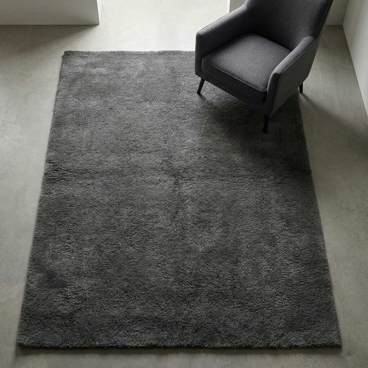Soft plush dark grey rectangular rug on concrete floor with armchair, modern non-shaggy rug for living room décor. __etsy:7548460815