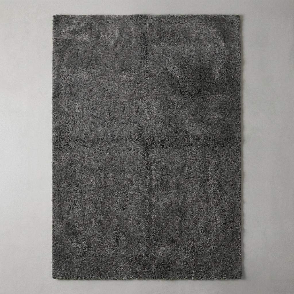 Modern grey plush area rug with smooth dense pile, styled in minimalist home interior with chair. __etsy:7548461153