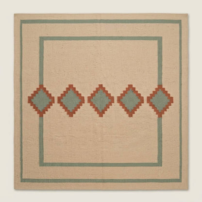 Southwestern Flatweave Wool Rug in beige with sage green borders and five terracotta diamonds with sage centres.