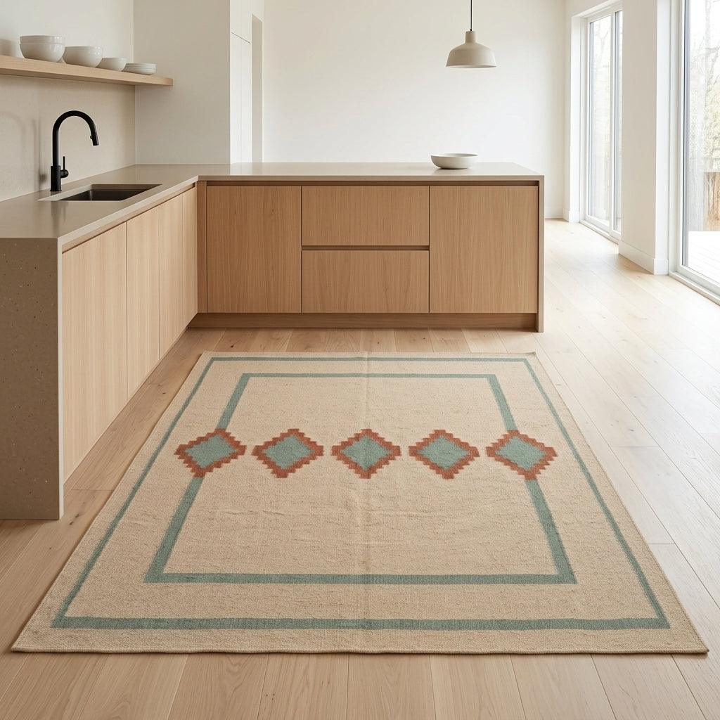 Southwestern Flatweave Wool Rug in natural beige with sage green borders and terracotta stepped diamonds with sage centres.