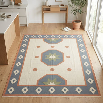 Southwestern Flatweave Wool Rug in ivory with dusty blue, peach and sage star medallions and a stepped diamond border.