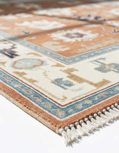 Terracotta Oushak rug with geometric tribal medallions in rust orange, navy, and cream tones, hand-tufted wool for Southwestern boho decor