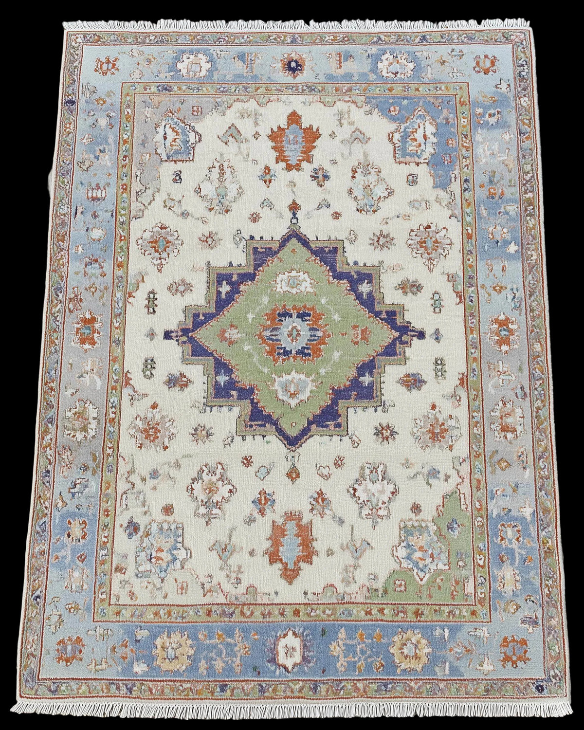 Full view of terracotta and blue floral Turkish-style rug, bohemian home decor.