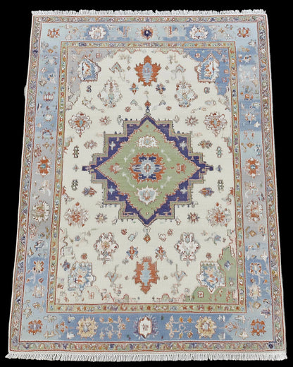 Full view of terracotta and blue floral Turkish-style rug, bohemian home decor.