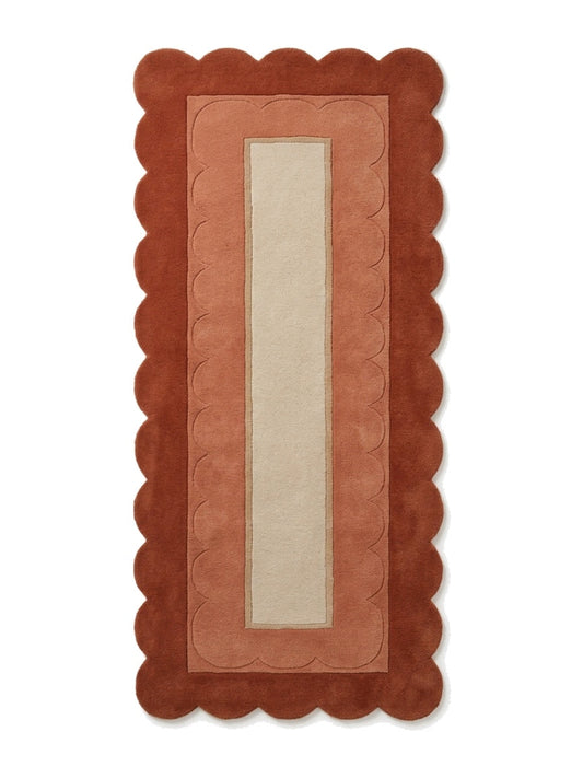 Terracotta Scalloped Runner Rug in rust and terracotta wool with a sand centre panel and carved scallop border