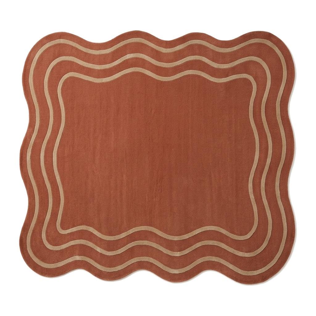 Terracotta Wavy Rug in rust with a soft wool appearance, irregular scalloped edges and cream wavy border lines