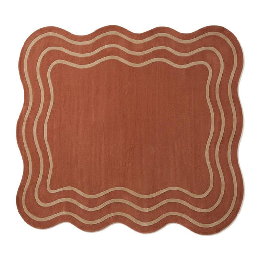 Terracotta Wavy Rug in rust with a soft wool appearance, irregular scalloped edges and cream wavy border lines