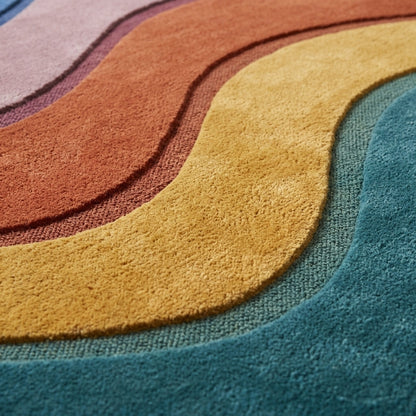 Wave Stripe Rug with plush wool pile in teal, mustard, rust and mauve, formed into flowing curved bands with carved outlines